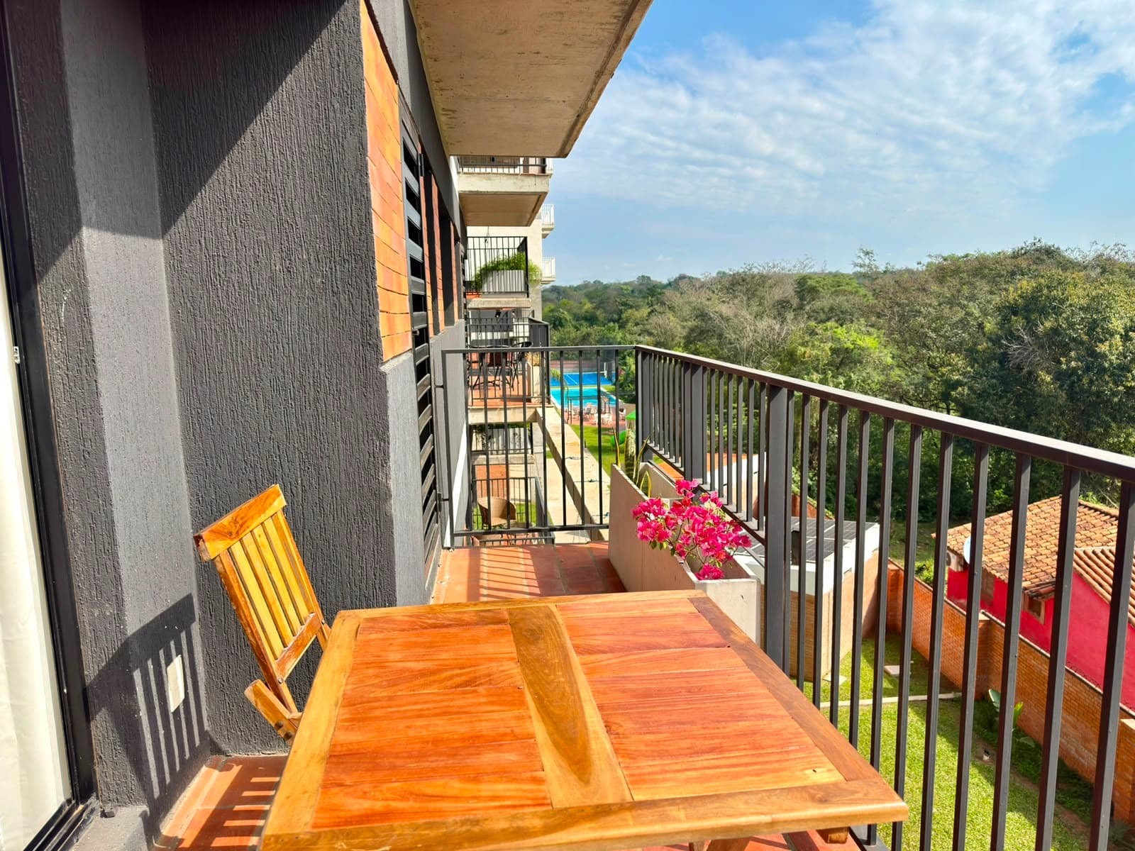Balcón con mesa y vista a las áreas verdes
