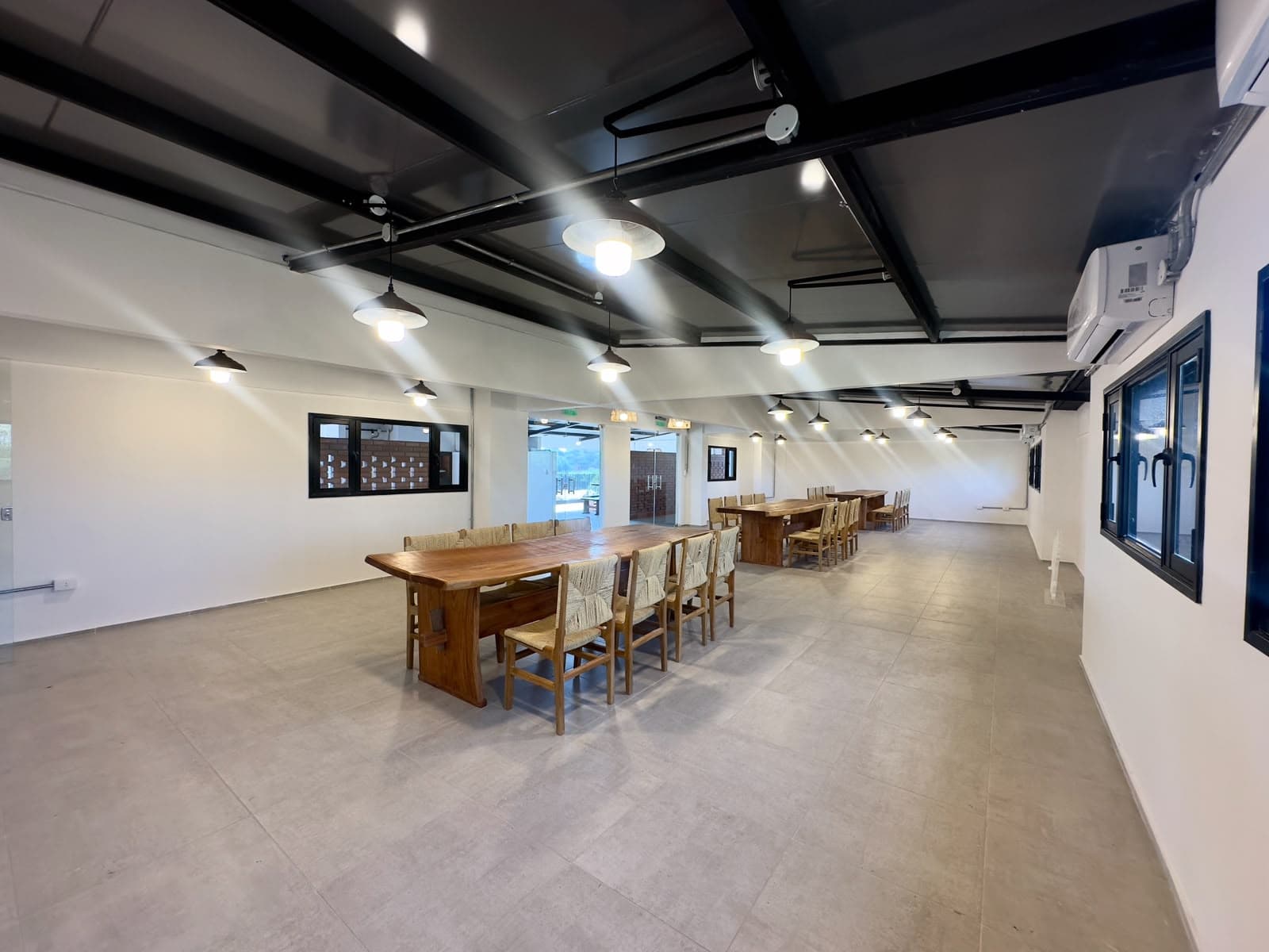 Amplio salón de eventos con mesas comunitarias